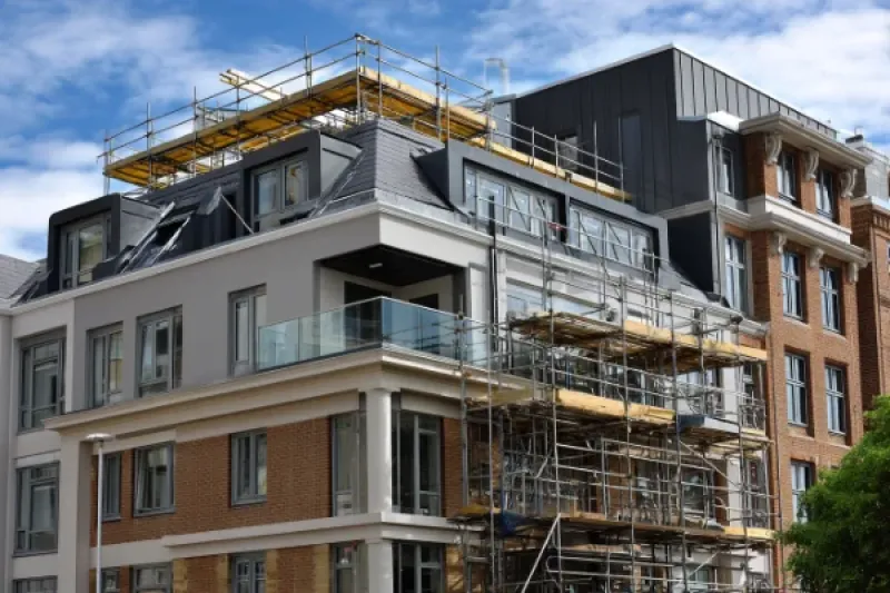 Mehrfamilienhaus, eingerüstet für einen Dachgeschossausbau