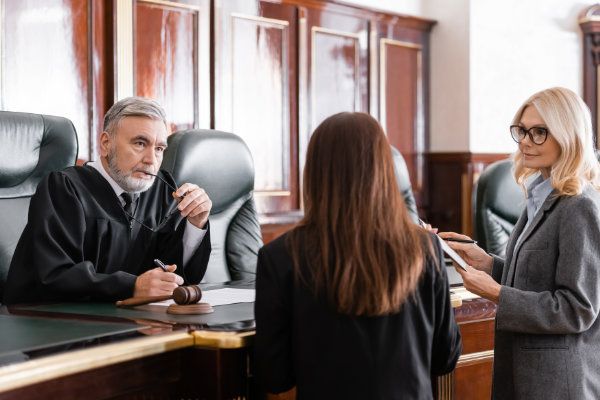 Richter unterhält sich mit zwei Frauen